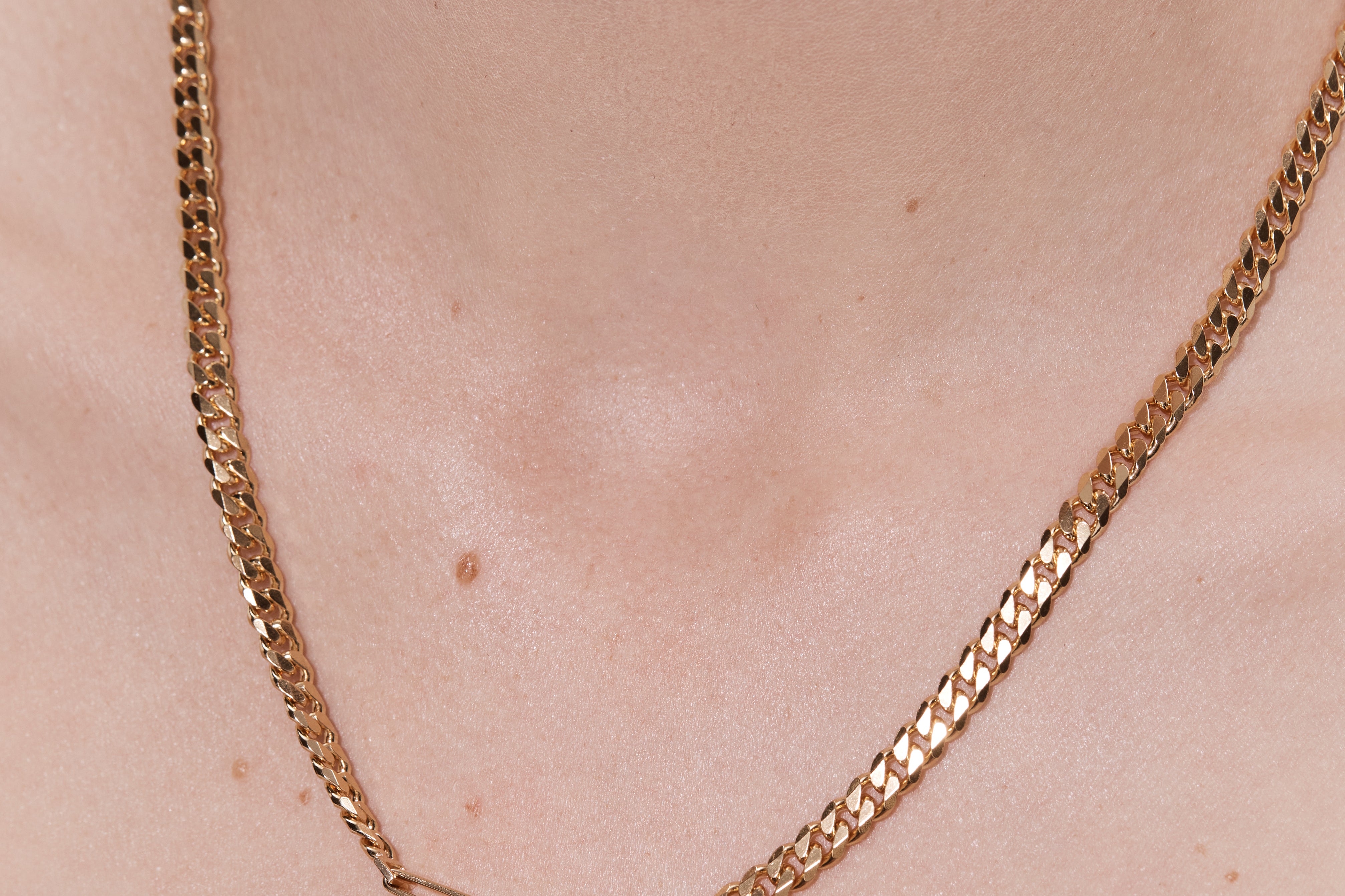 woman wearing gold cuban link chain necklace layered