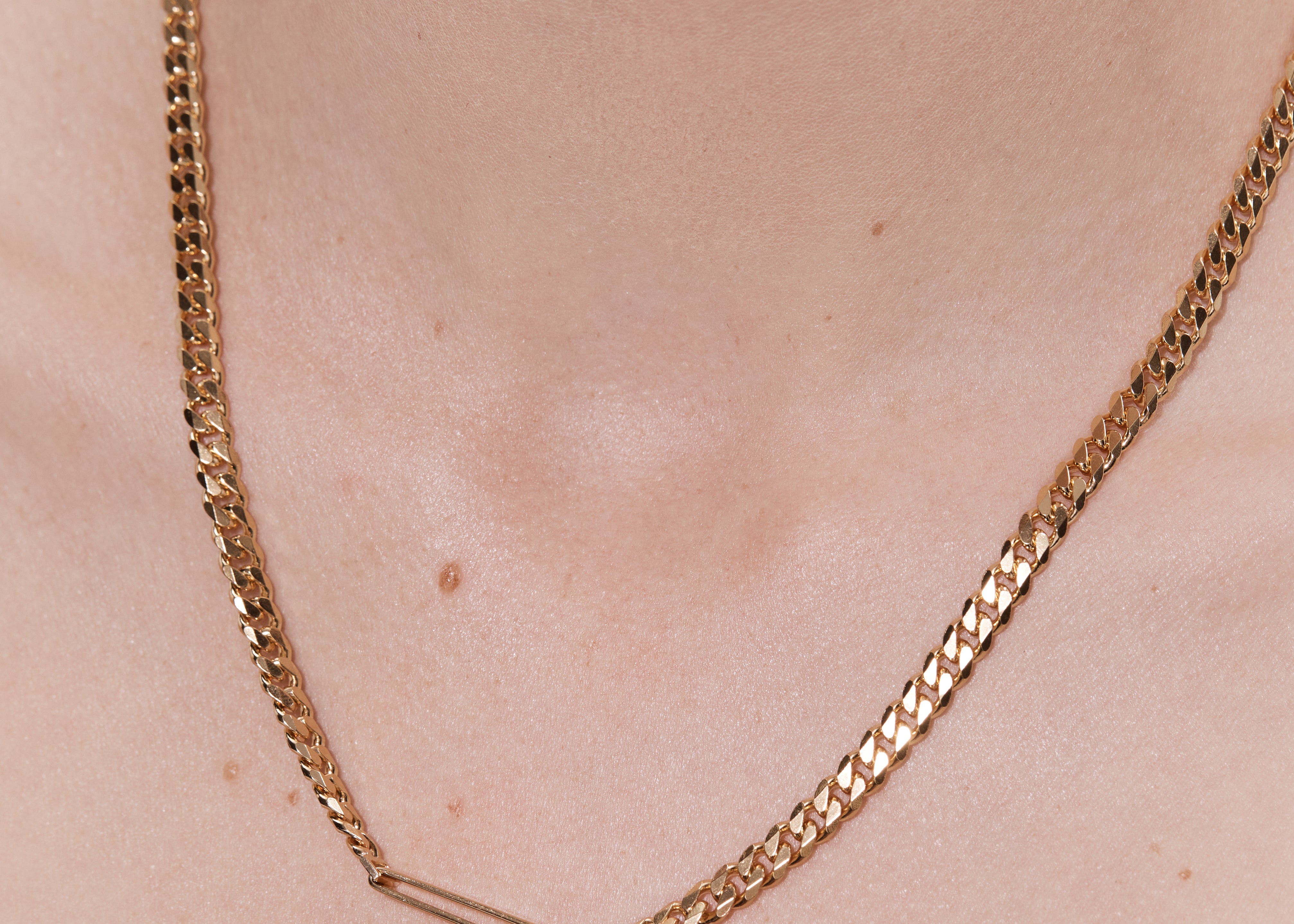 woman wearing gold cuban link chain necklace layered