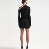 A model wearing a black asymmetric neckline, long-sleeved, mini-length dress by sener besim