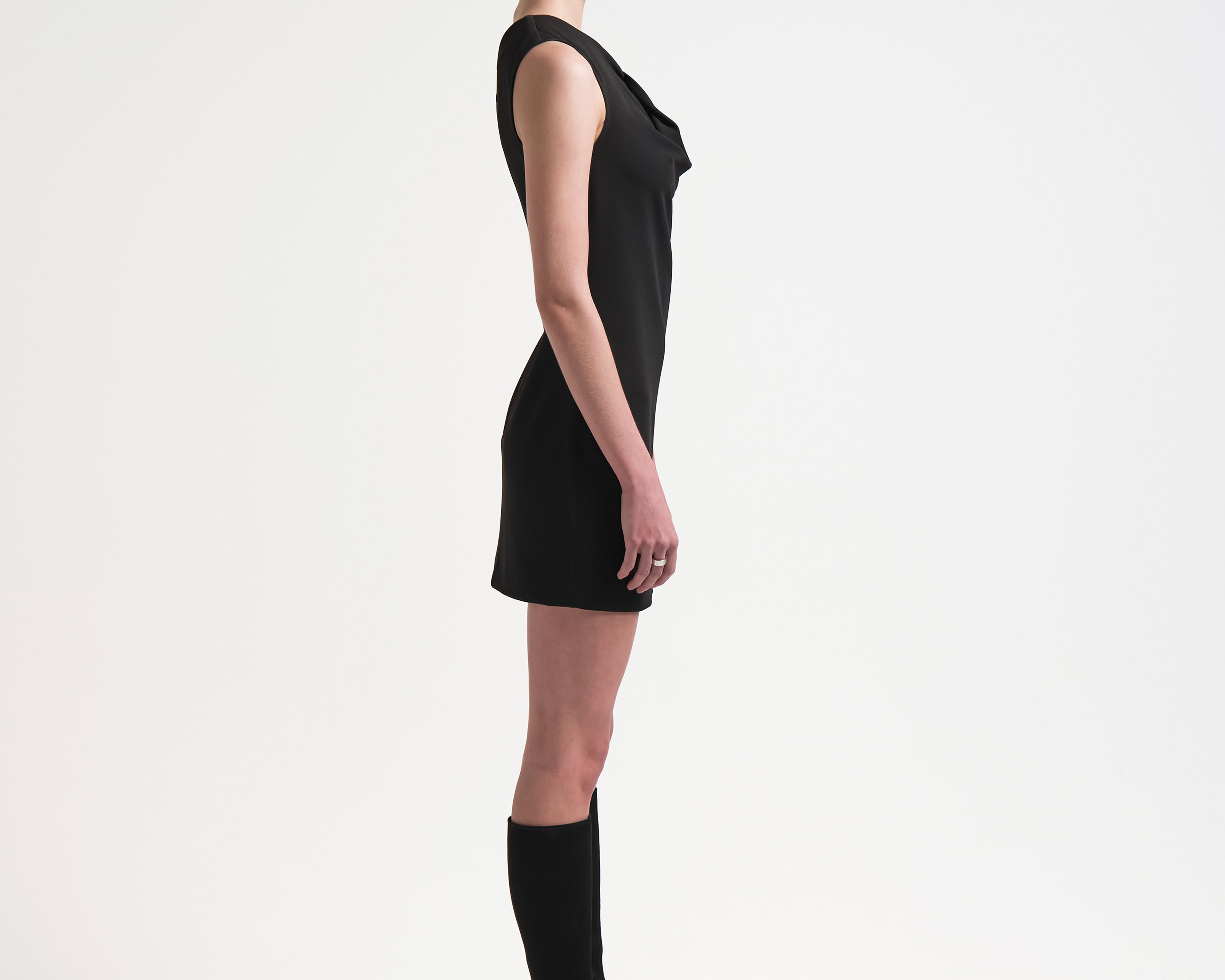 side view of model wearing black one shouldered dress with an asymmetric neckline by sener besim
