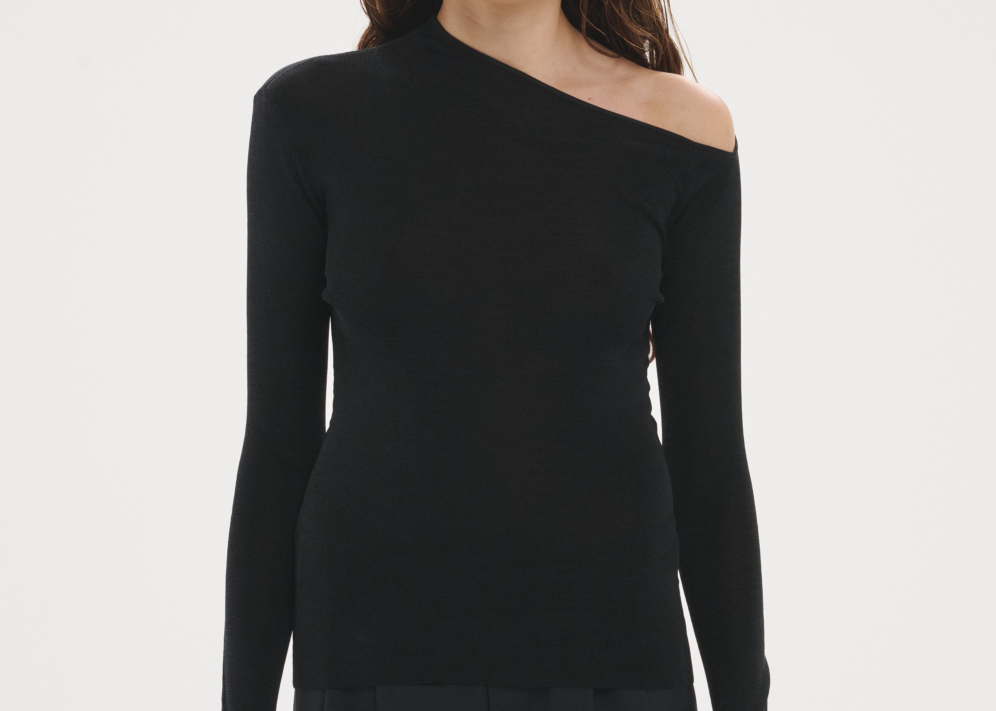 Şener Besim Angular Neck Top in Black, showing the asymmetric neckline