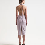 model wearing backless vegan leather dress with ties and a mid length by sener besim