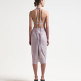 model wearing backless vegan leather dress with ties and a mid length by sener besim
