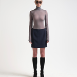 A model wearing a high-waisted, knee-length bonded mini skirt in navy colour by sener besim