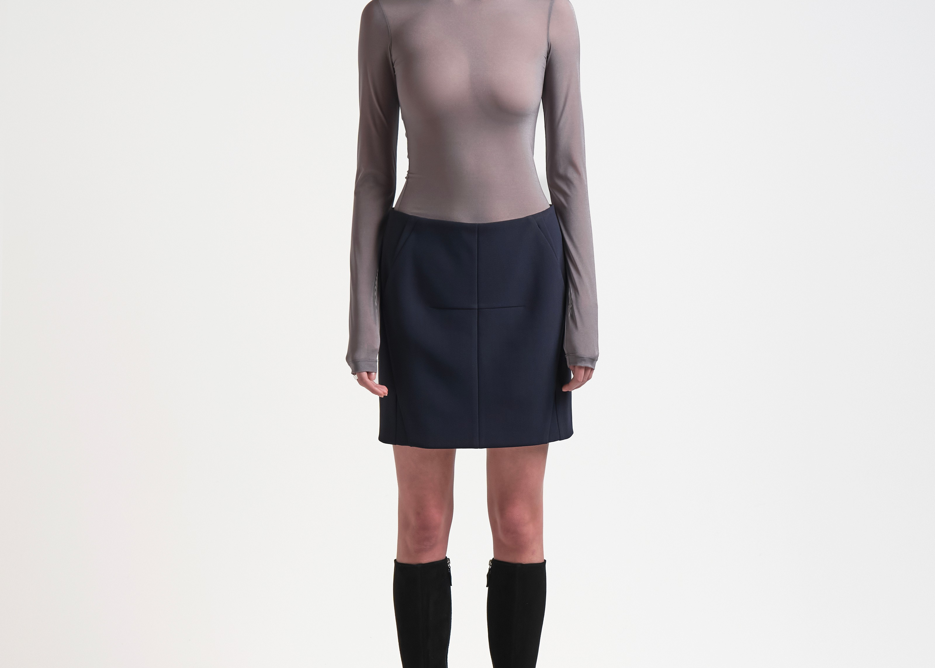 A model wearing a high-waisted, knee-length bonded mini skirt in navy colour by sener besim