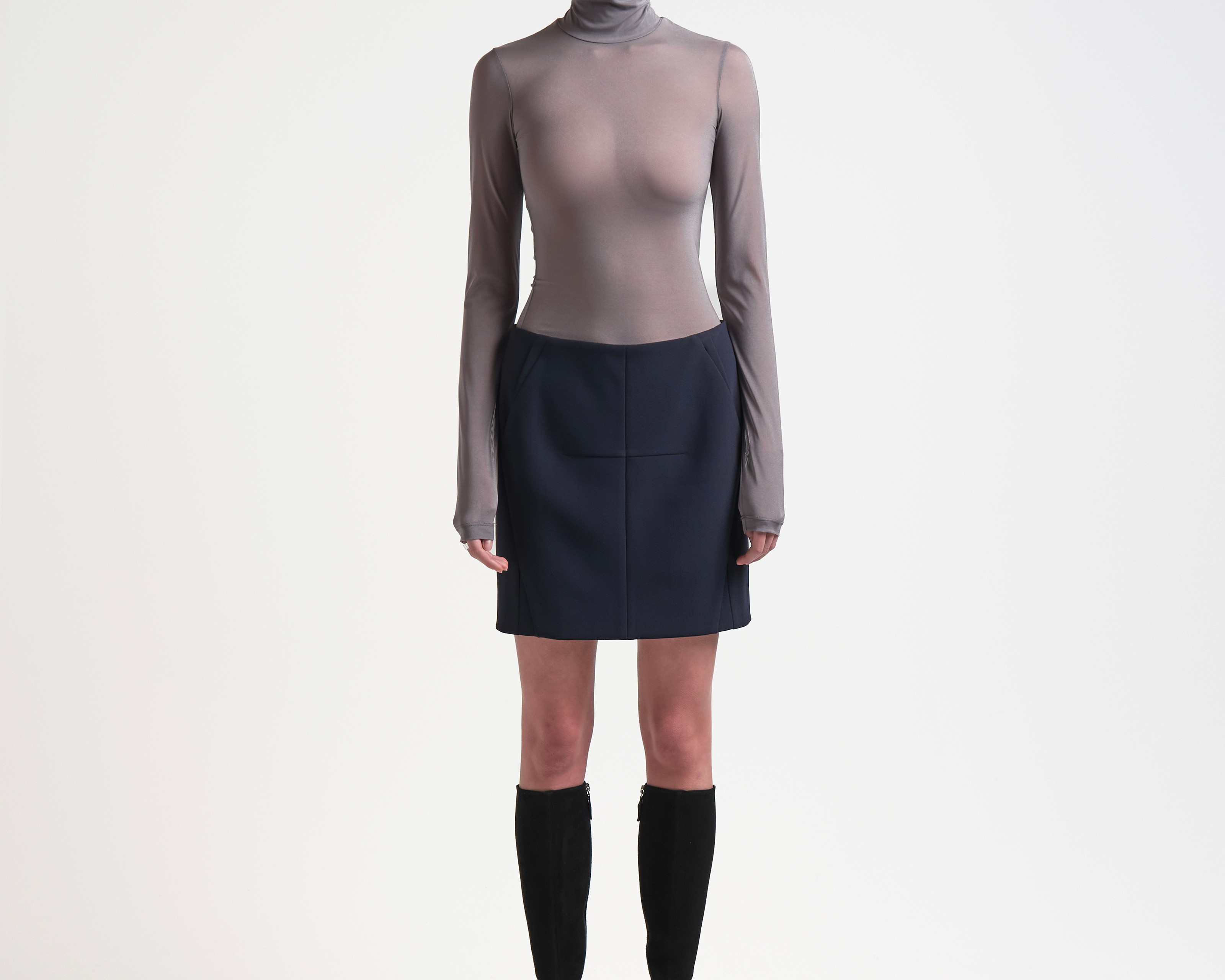 A model wearing a high-waisted, knee-length bonded mini skirt in navy colour by sener besim