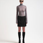 model wearing high waist bonded mini skirt in black by sener besim