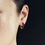 Şener Besim Enamel Huggie burgundy gold worn on ear, editorial shot