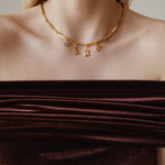 Şener Besim Horoscope Charms in gold, worn layered on chain necklace