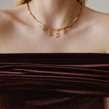 Şener Besim Horoscope Charms in gold, worn layered on chain necklace