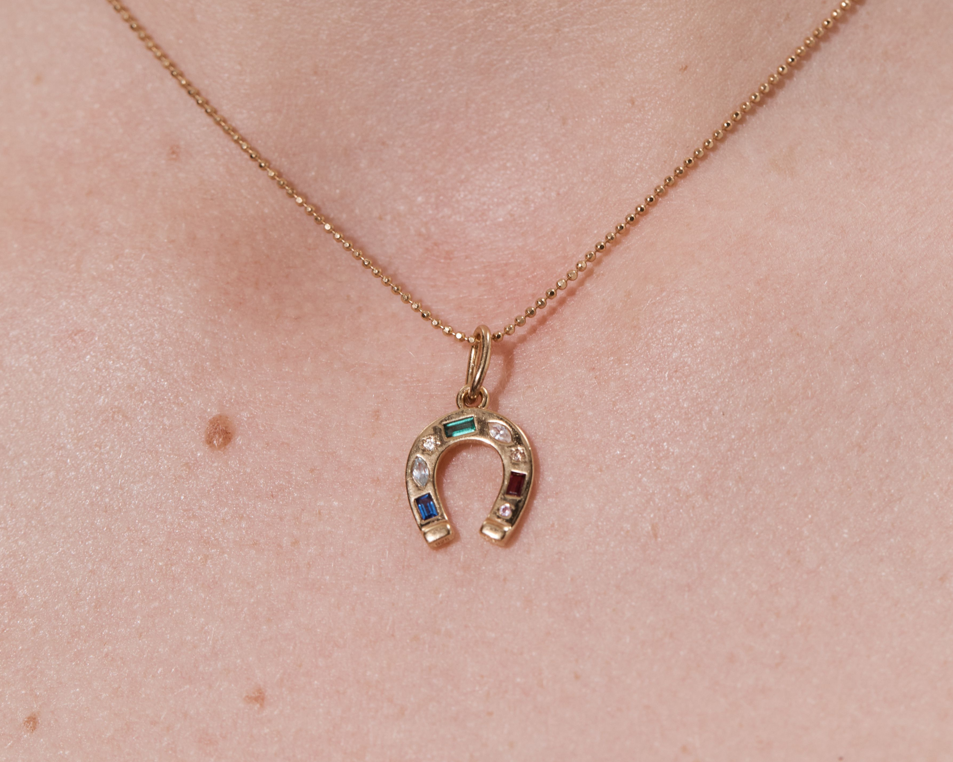 Şener Besim Horseshoe With Gems Charm worn as a necklace pendant