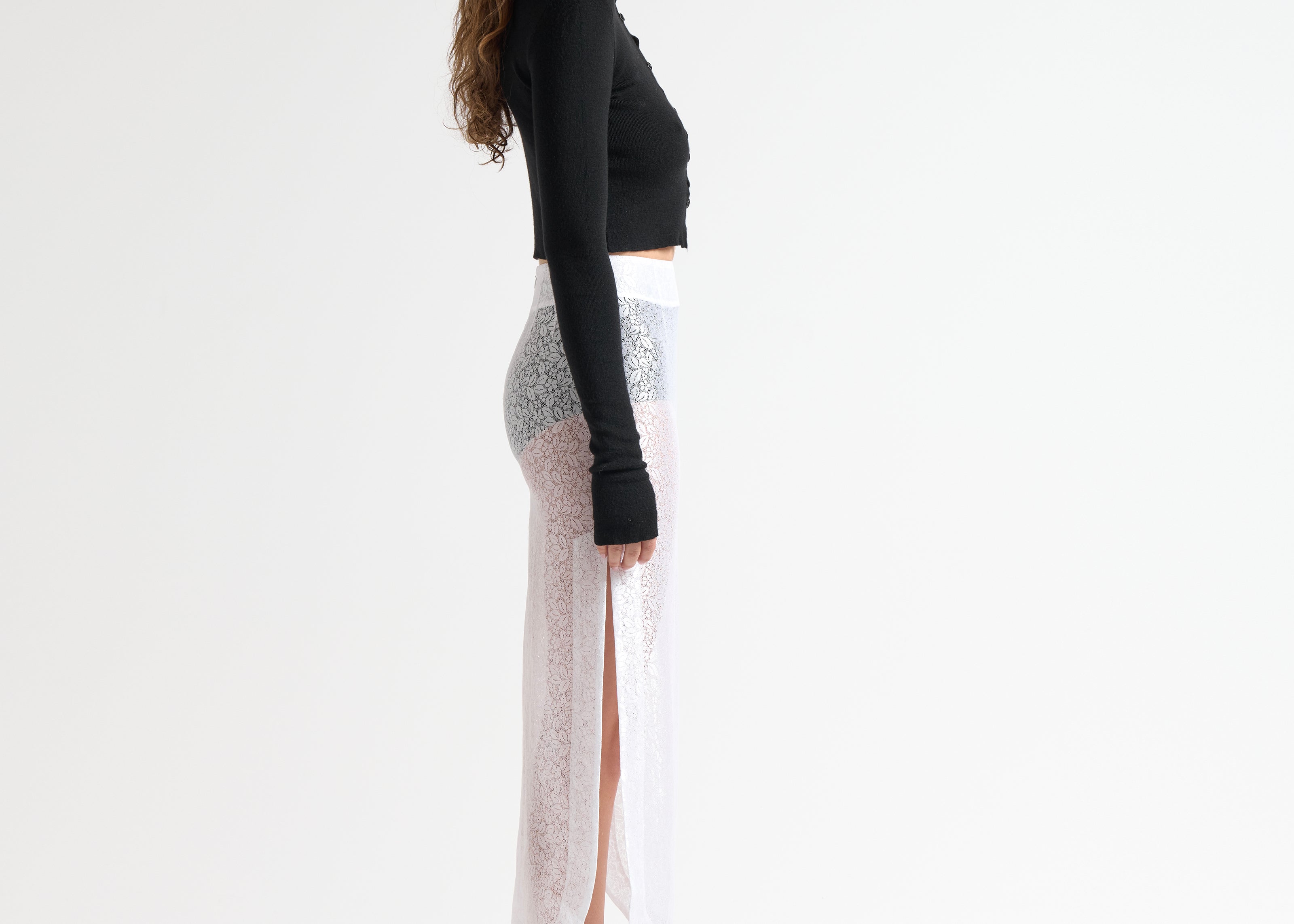 side view of model wearing sheer lace skirt with side splits by sener besim