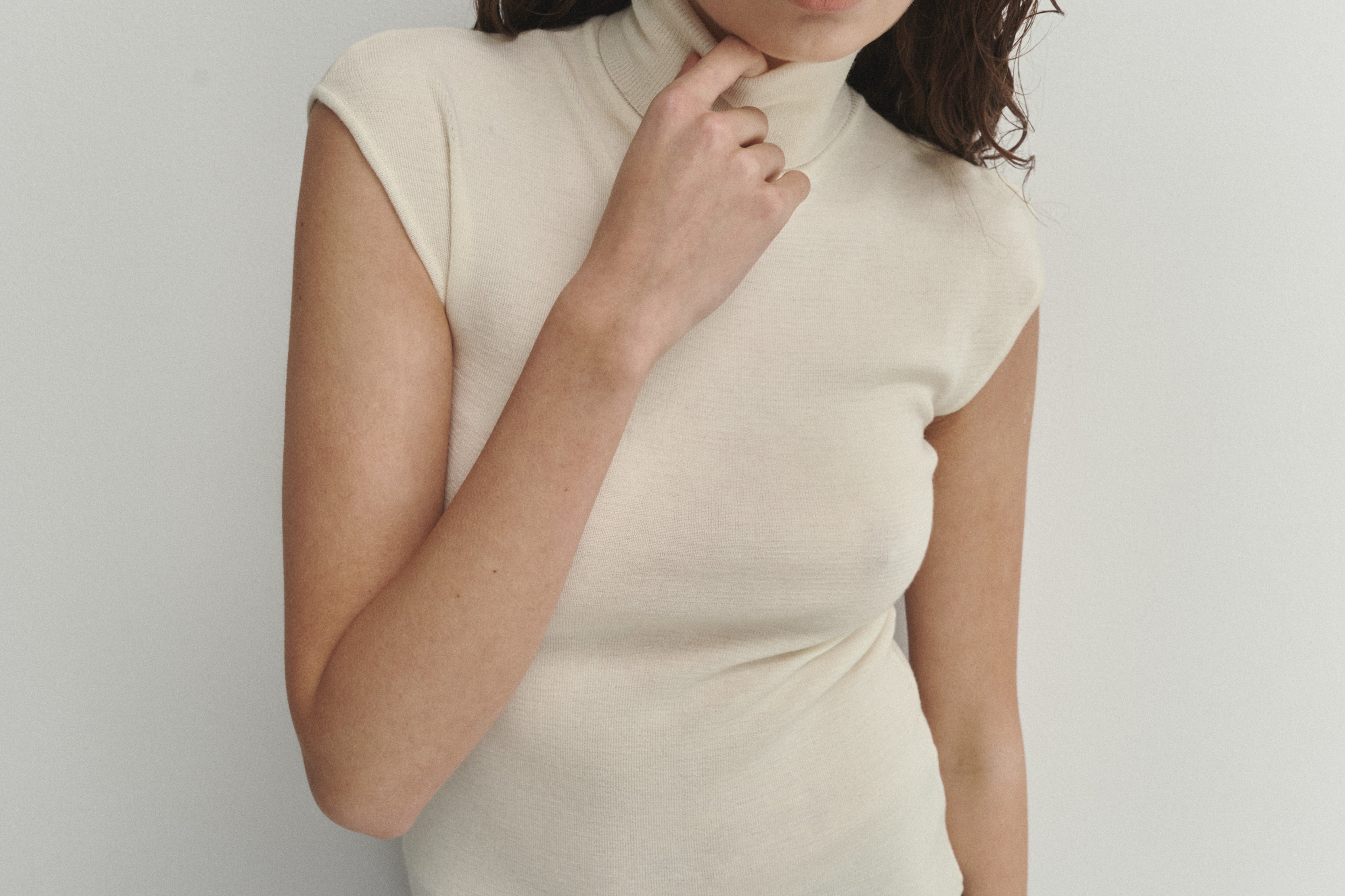 Şener Besim Merino Cap Sleeve Top in White, close-up showing the high turtleneck