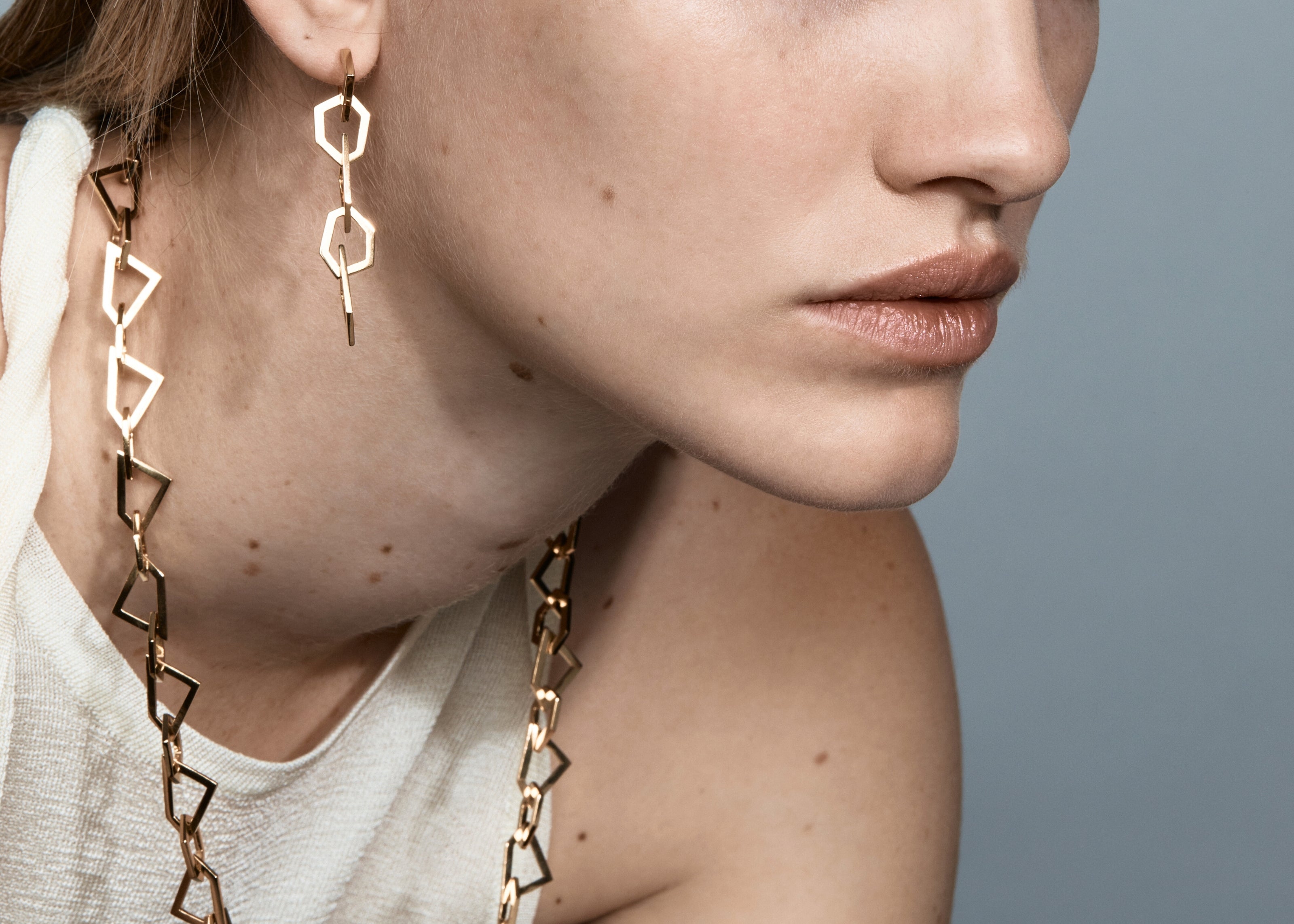 Şener Besim Mosaic Long Earring gold worn on ear, geometric chain links, editorial shot