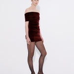 Şener Besim Off Shoulder Mini Dress in burgundy velvet, worn side view