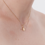 Şener Besim Paw Print Charm worn as a necklace pendant in gold plating