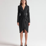 Woman wearing a black dress with long sleeves with knot detail by sener besim