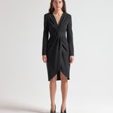 Woman wearing a black dress with long sleeves with knot detail by sener besim