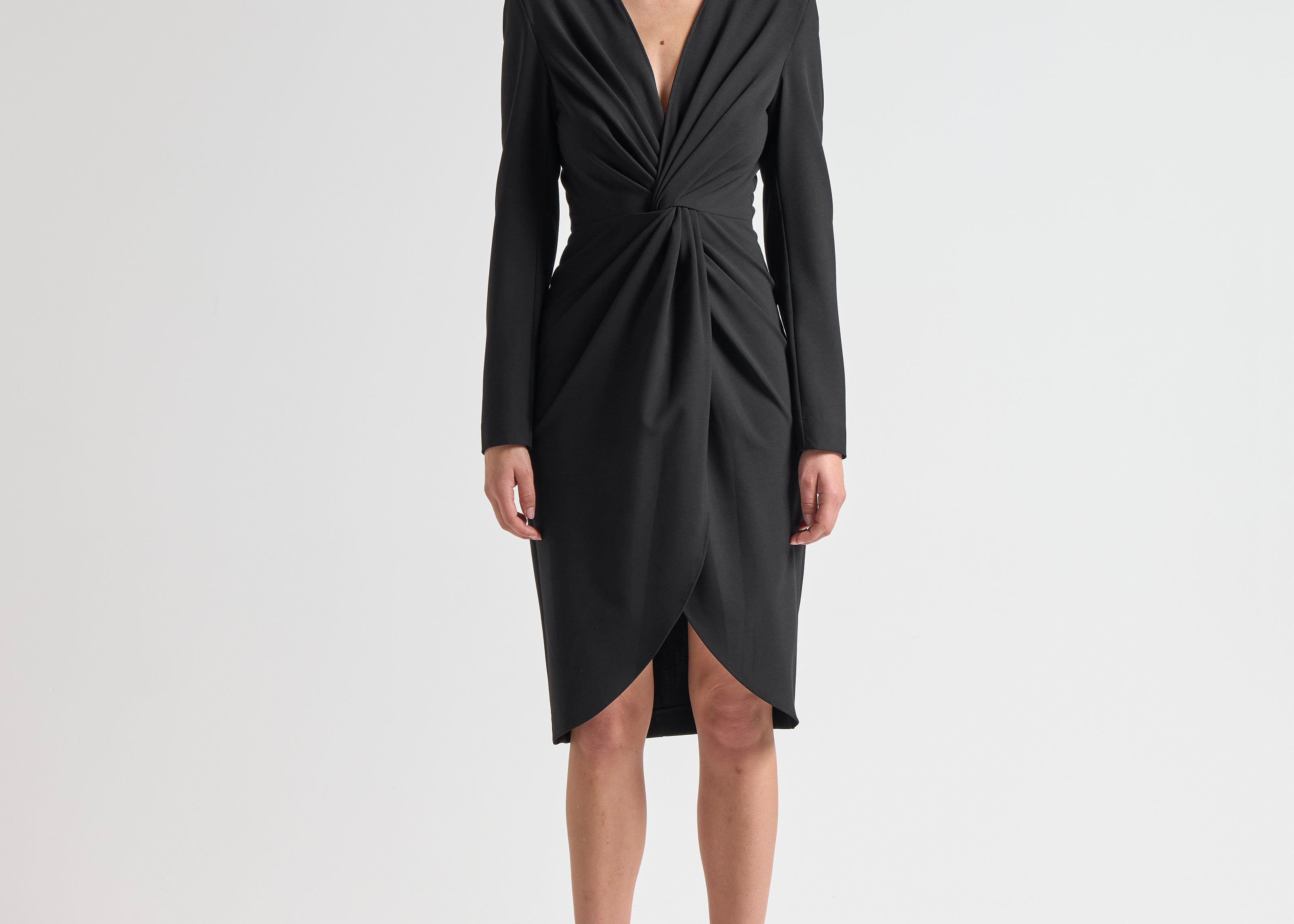 Woman wearing a black dress with long sleeves with knot detail by sener besim
