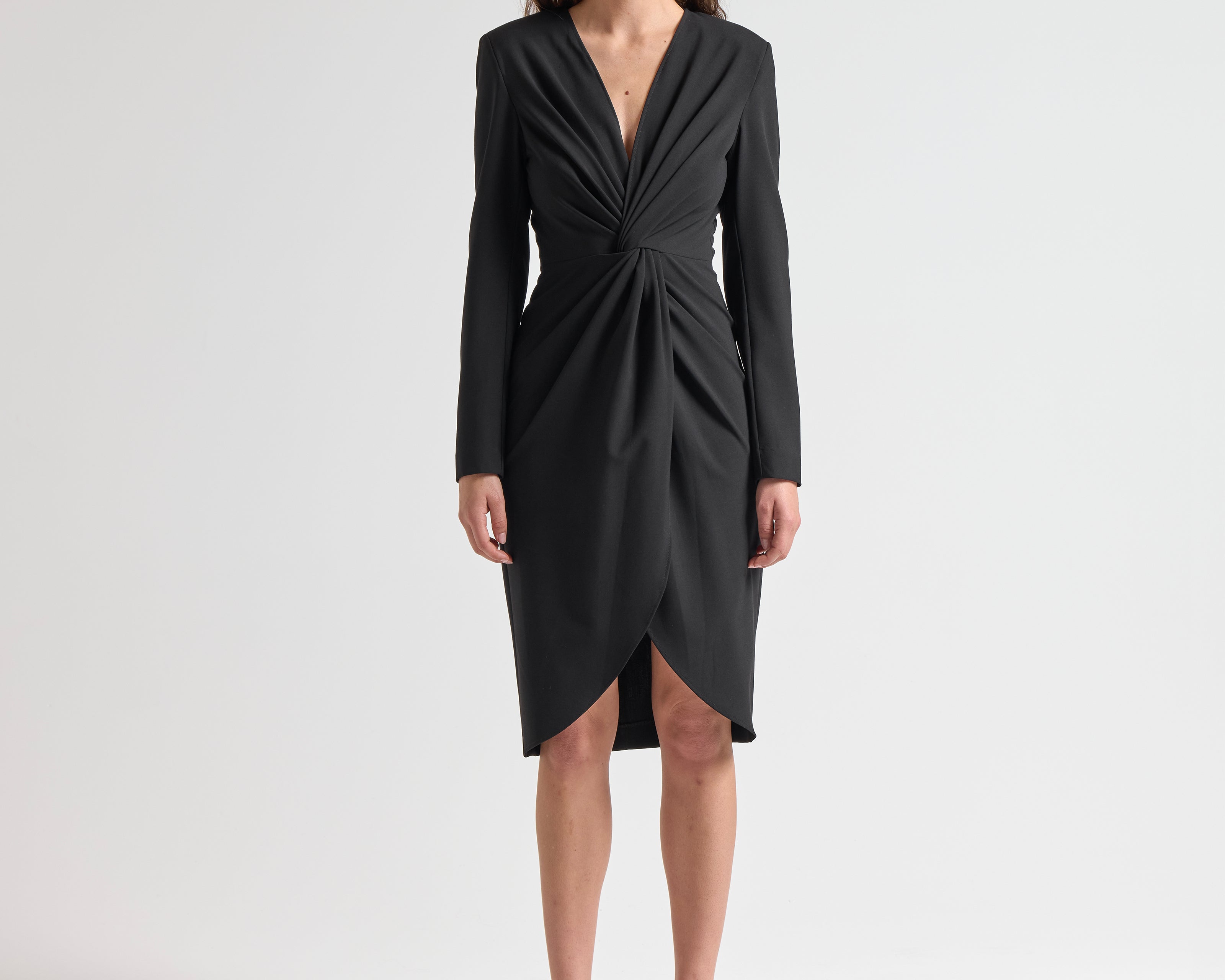 Woman wearing a black dress with long sleeves with knot detail by sener besim