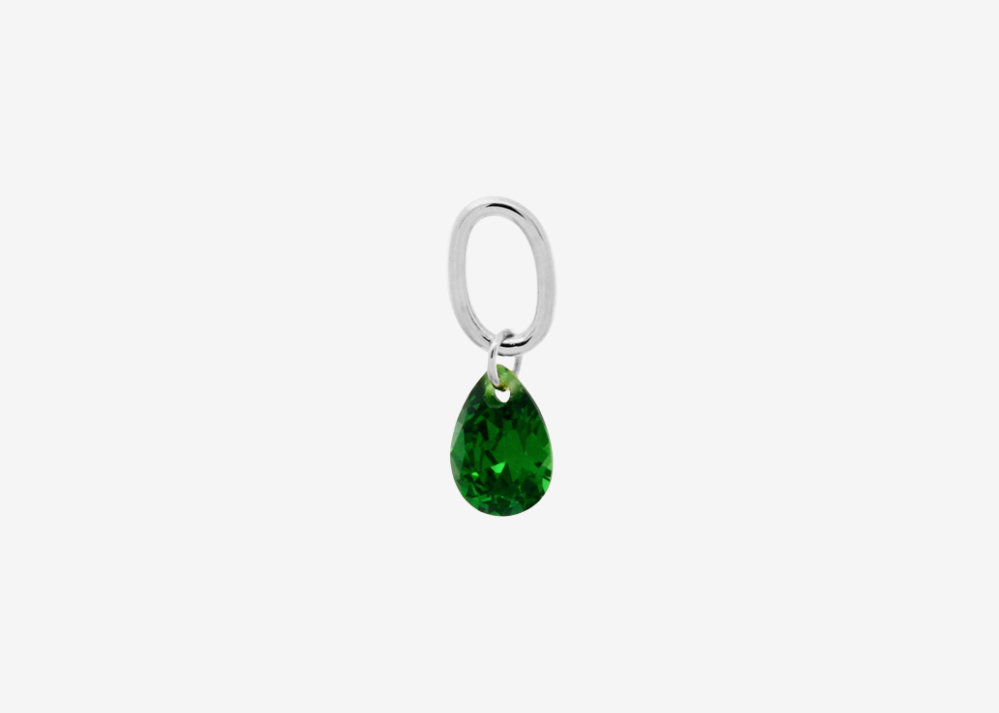 Şener Besim Teardrop Charm with emerald cubic zirconia in rhodium plating, flat lay