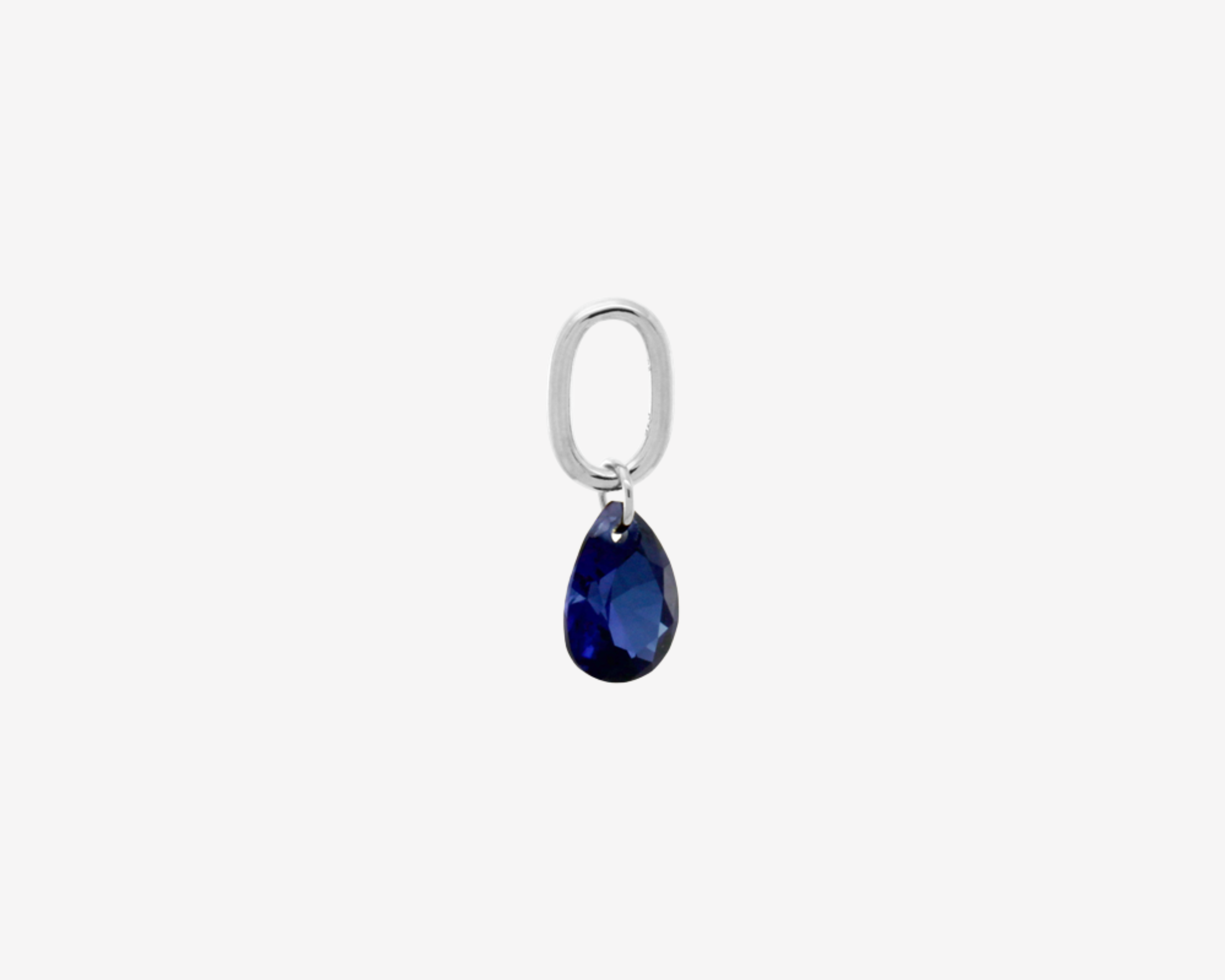 Şener Besim Teardrop Charm with sapphire cubic zirconia in rhodium plating, flat lay