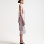 model wearing apron-front silhouette with an open back with ties by sener besim
