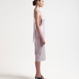 model wearing apron-front silhouette with an open back with ties by sener besim