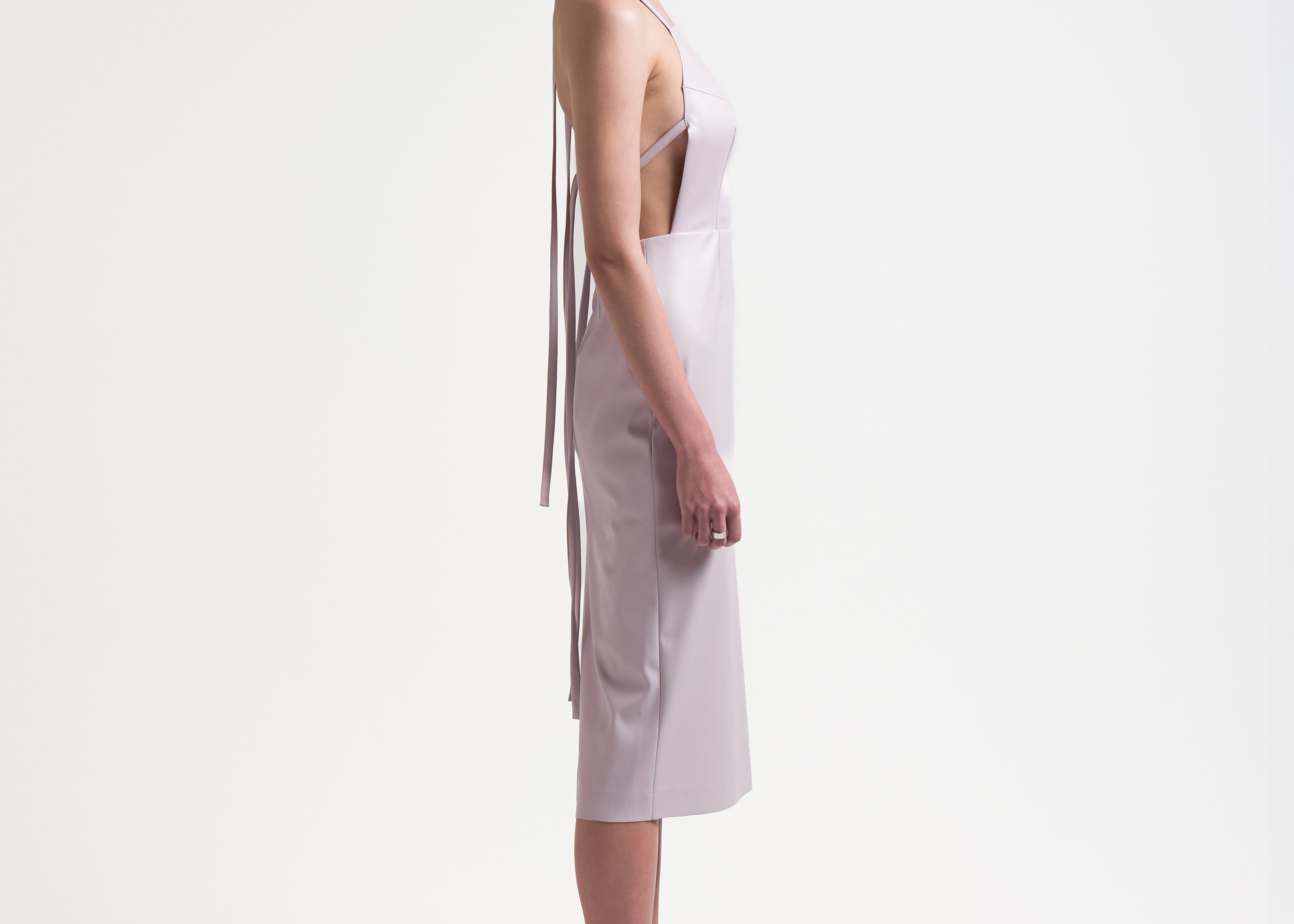 model wearing apron-front silhouette with an open back with ties by sener besim