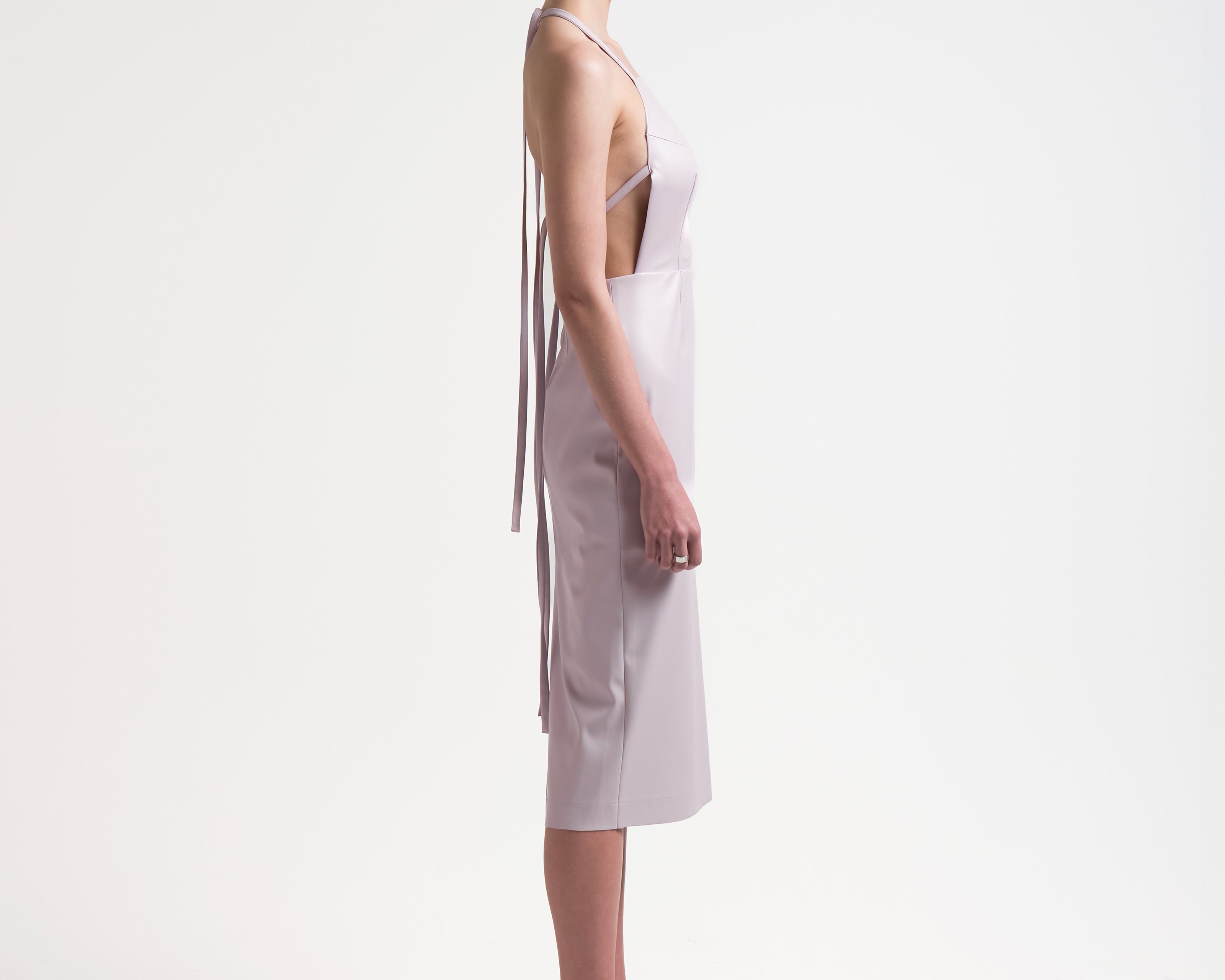 model wearing apron-front silhouette with an open back with ties by sener besim