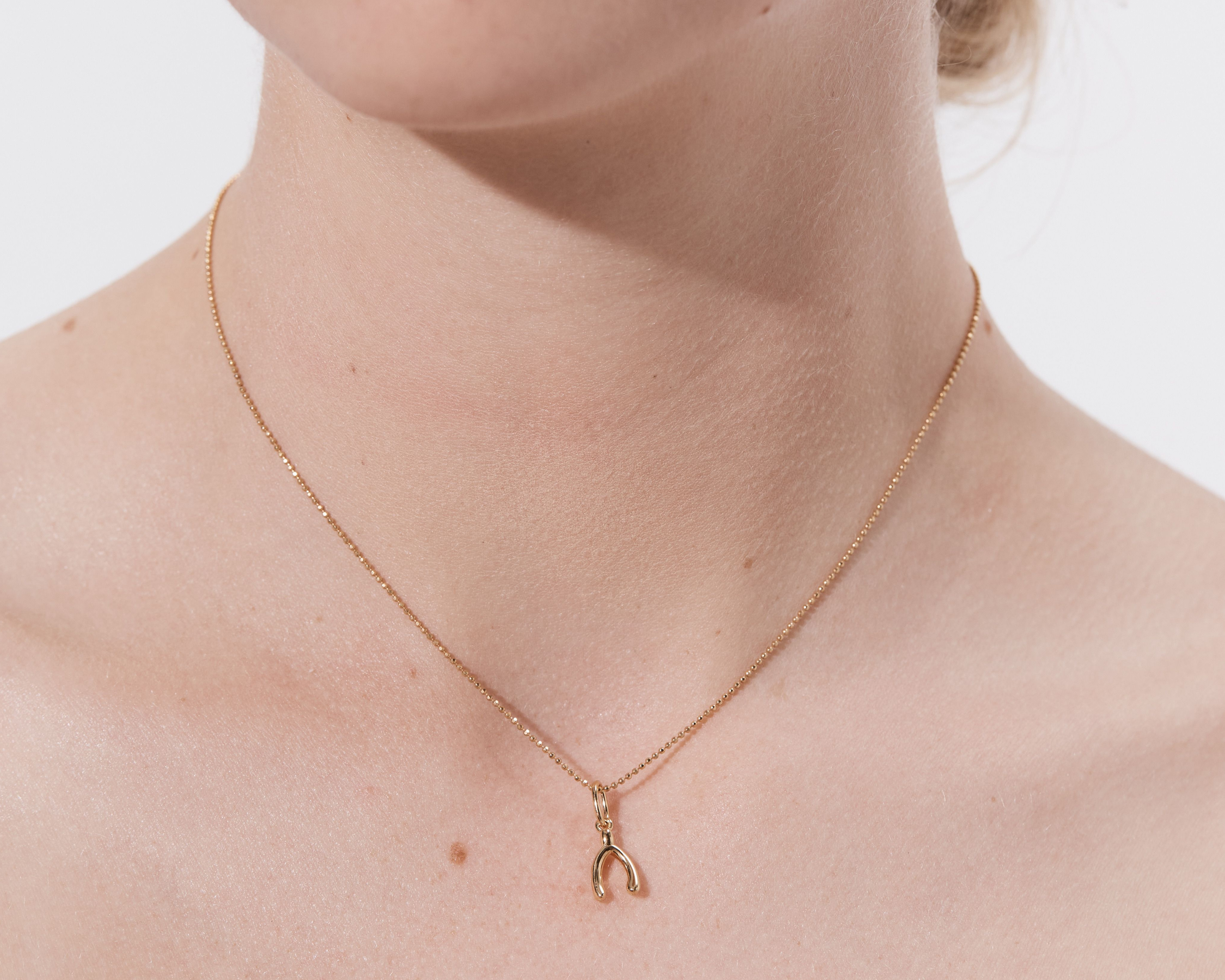 Şener Besim Wishbone Charm worn on necklace — sterling silver