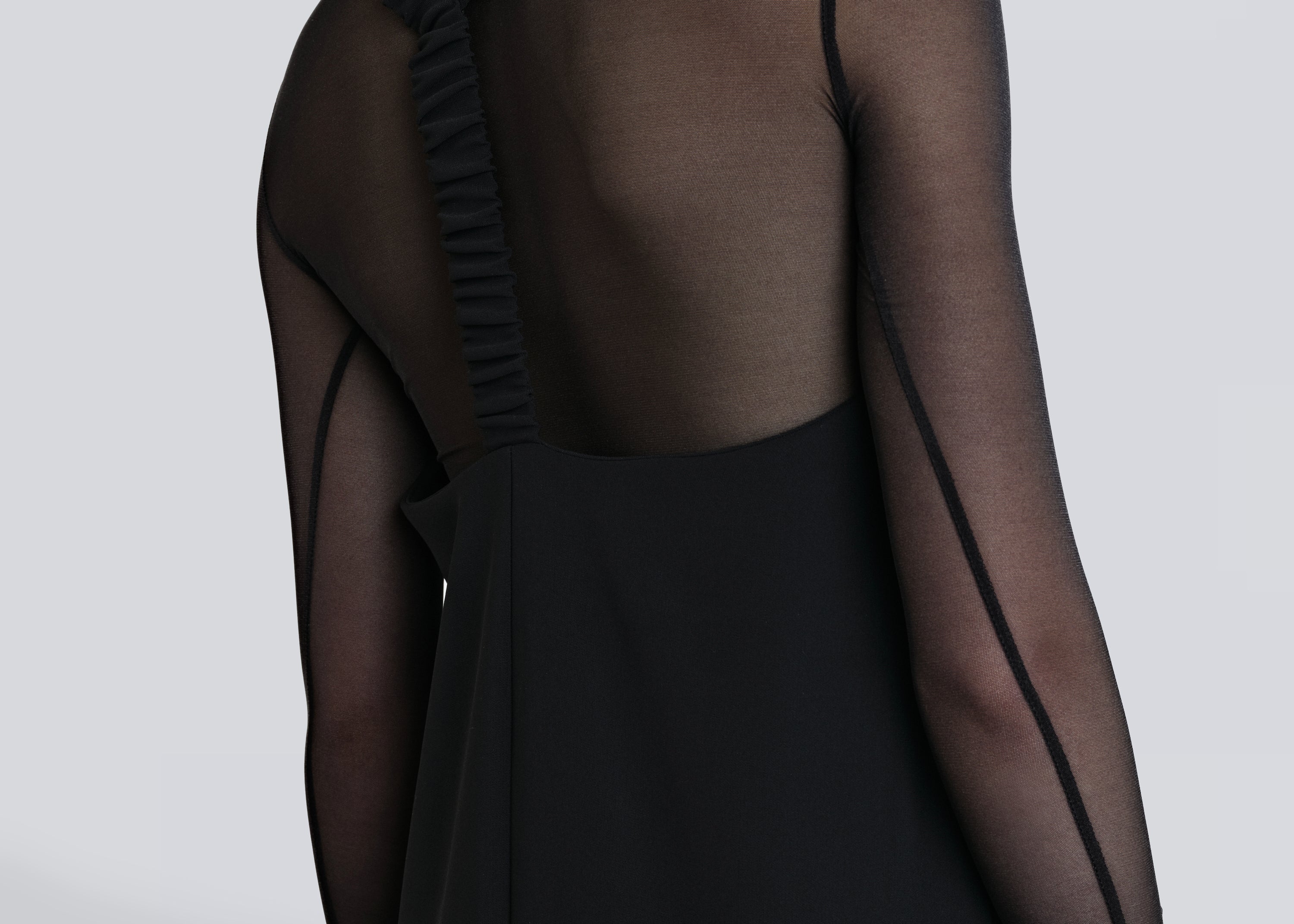 Model wearing Şener Besim Y Back Dress in black, midi length