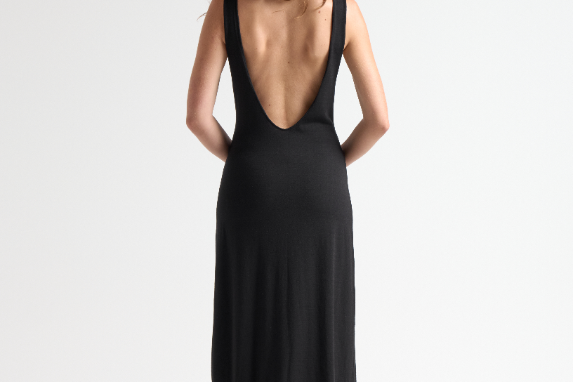 model wearing black open back dress with full length by sener besim