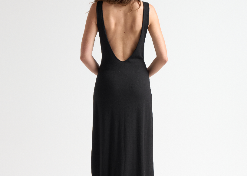 model wearing black open back dress with full length by sener besim