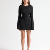 model in open back mini dress with long flared sleeves by sener besim