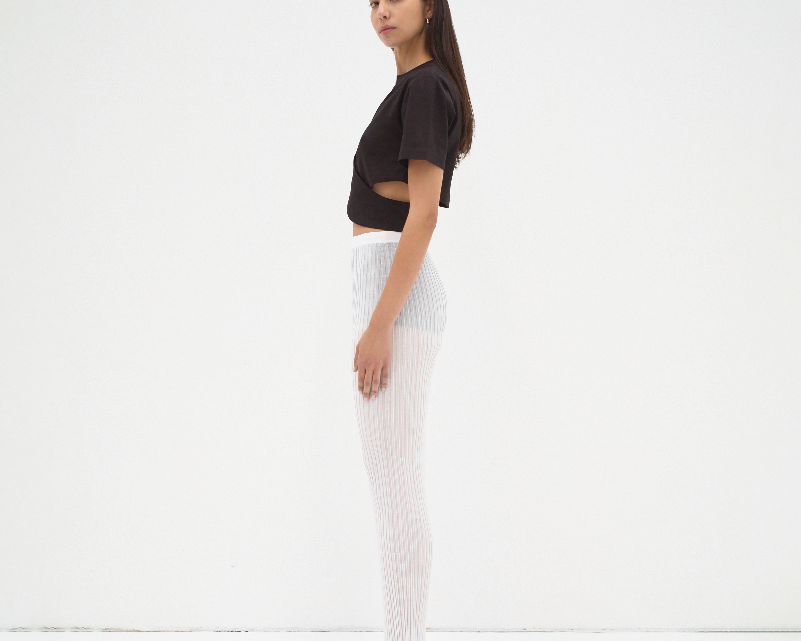 model wearing cropped tee with cut out detail in black by sener besim