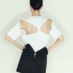 model wearing mini pencil skirt by sener besim featuring zip detail at back