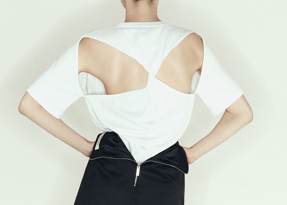 model wearing mini pencil skirt by sener besim featuring zip detail at back