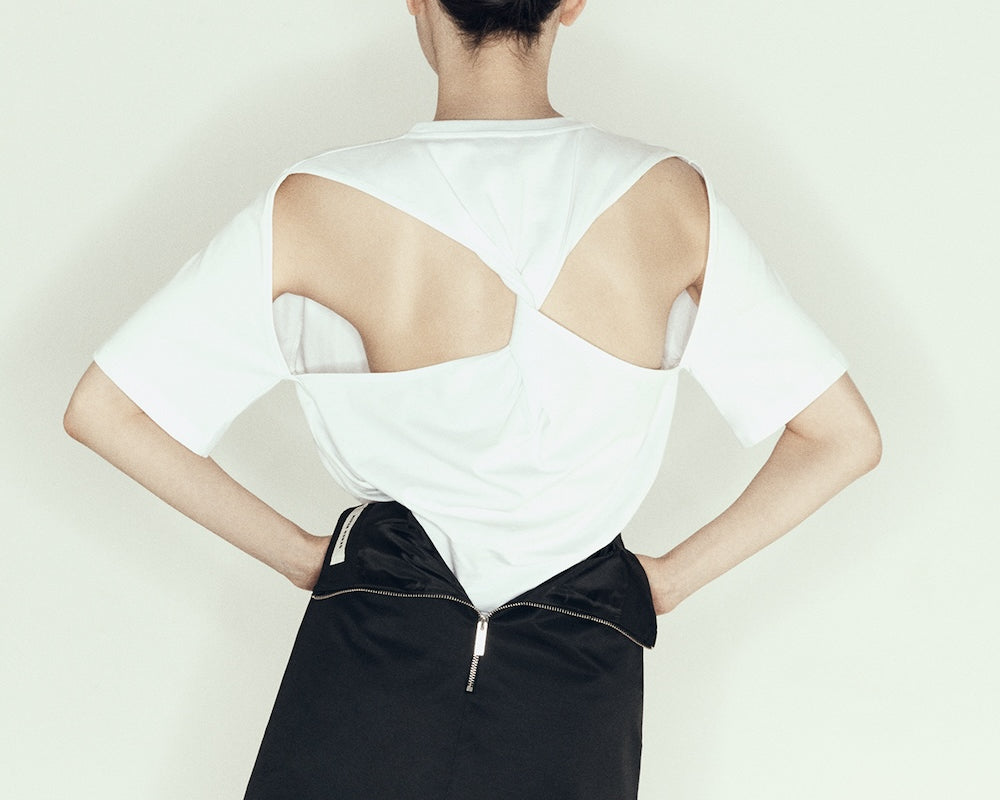 model wearing mini pencil skirt by sener besim featuring zip detail at back