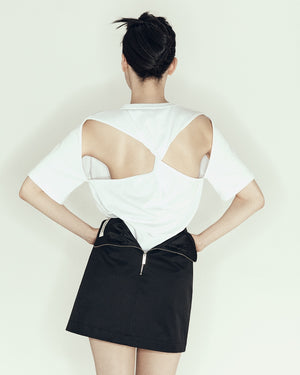 model wearing mini pencil skirt by sener besim featuring zip detail at back