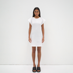 model wearing a white mini dress with an open back detail and cap sleeve by sener besim