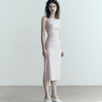 model in sener besim apron style dress with ties in pale pink
