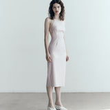 model in sener besim apron style dress with ties in pale pink