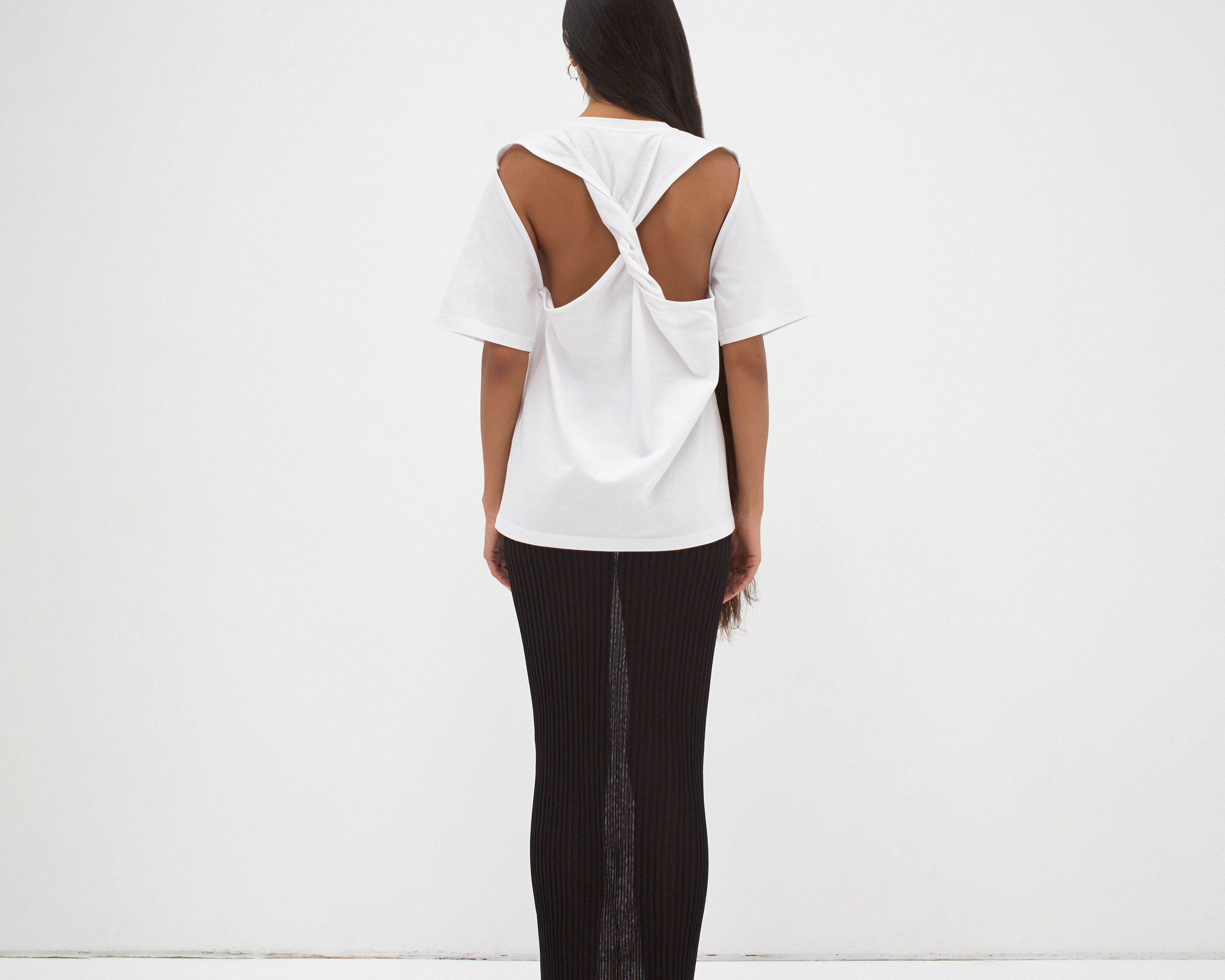 back view of model wearing boxy tee with cut out back detail medium length