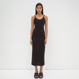 A model wearing a mid-calf length black dress with twisted strap features by sener besim