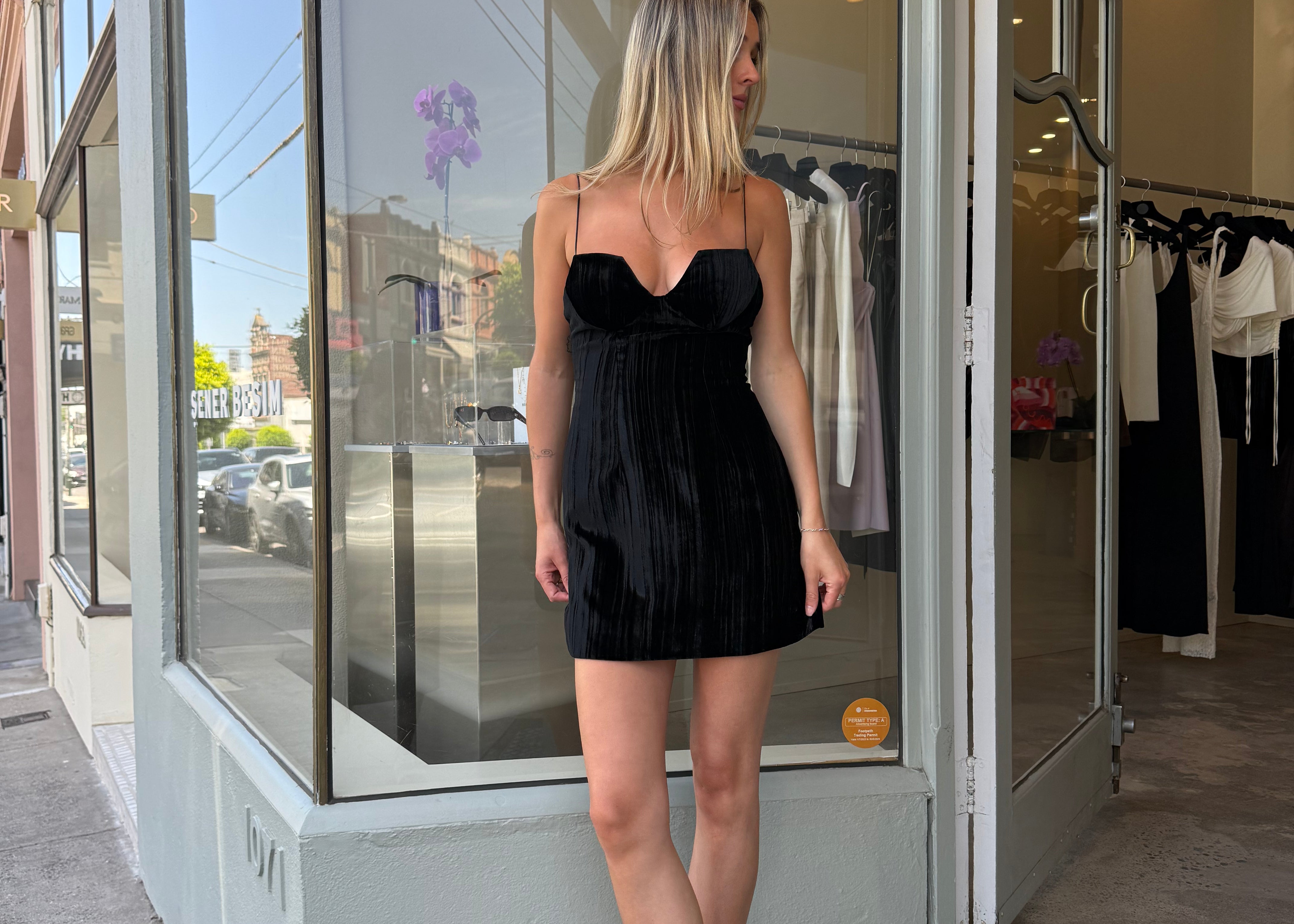 Black velvet mini dress with sweetheart neckline, street style front view — Şener Besim
