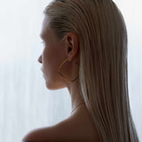 model wearing sener besim large statement thin earrings