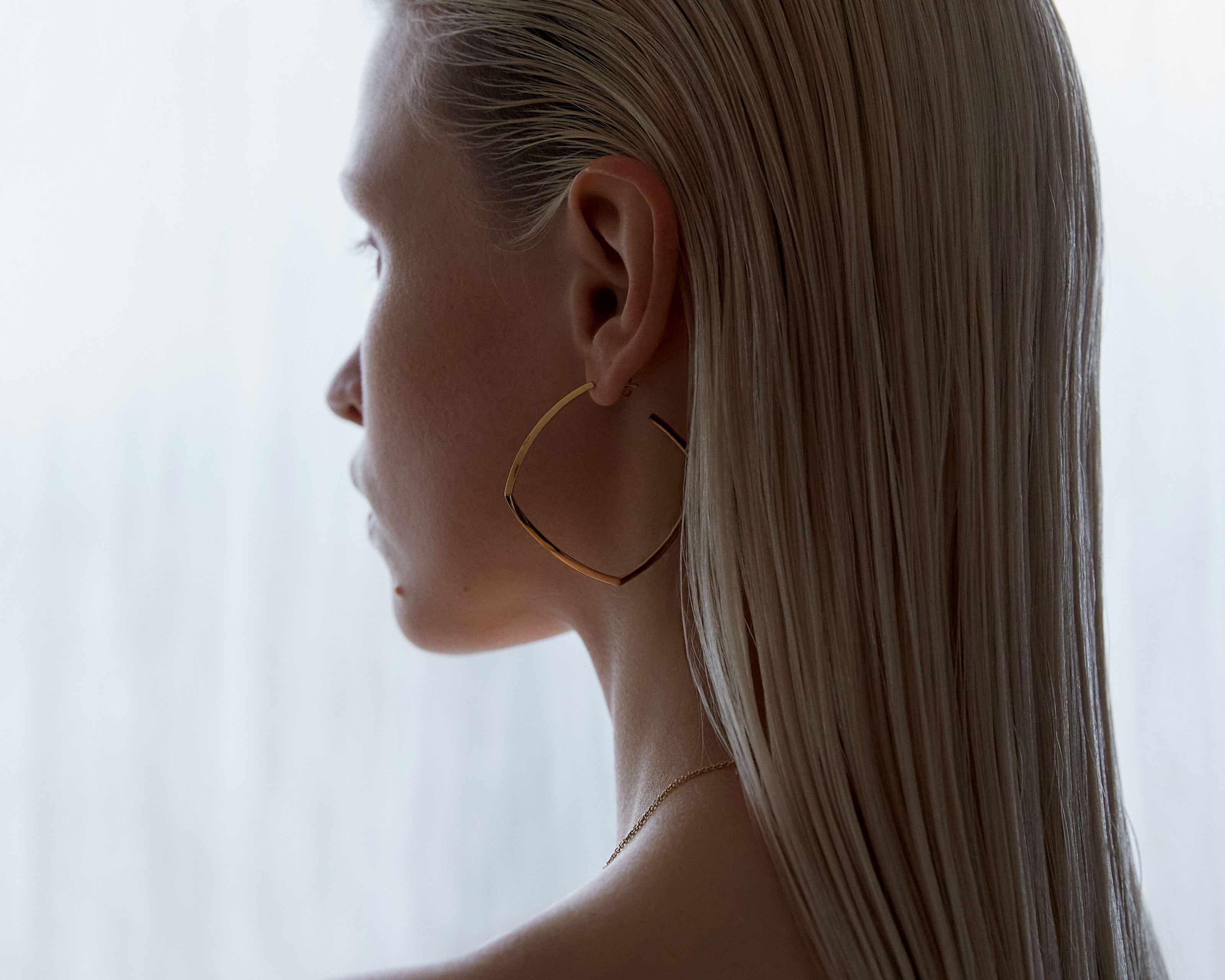 model wearing sener besim large statement thin earrings