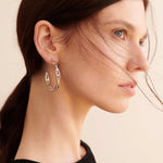 Şener Besim Large Helix Hoops silver worn on ear, sculptural helix design, rhodium plating