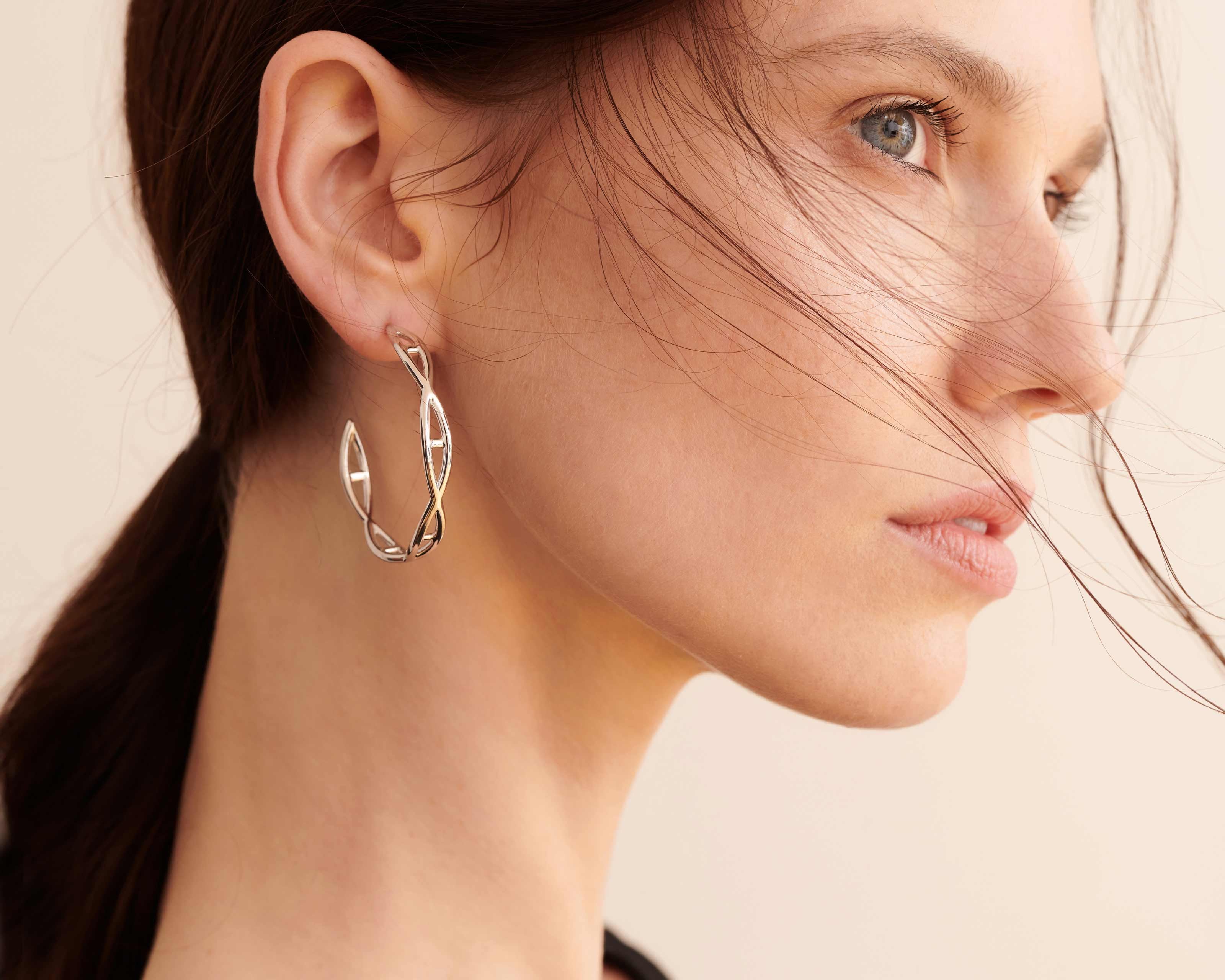 Şener Besim Large Helix Hoops silver worn on ear, sculptural helix design, rhodium plating